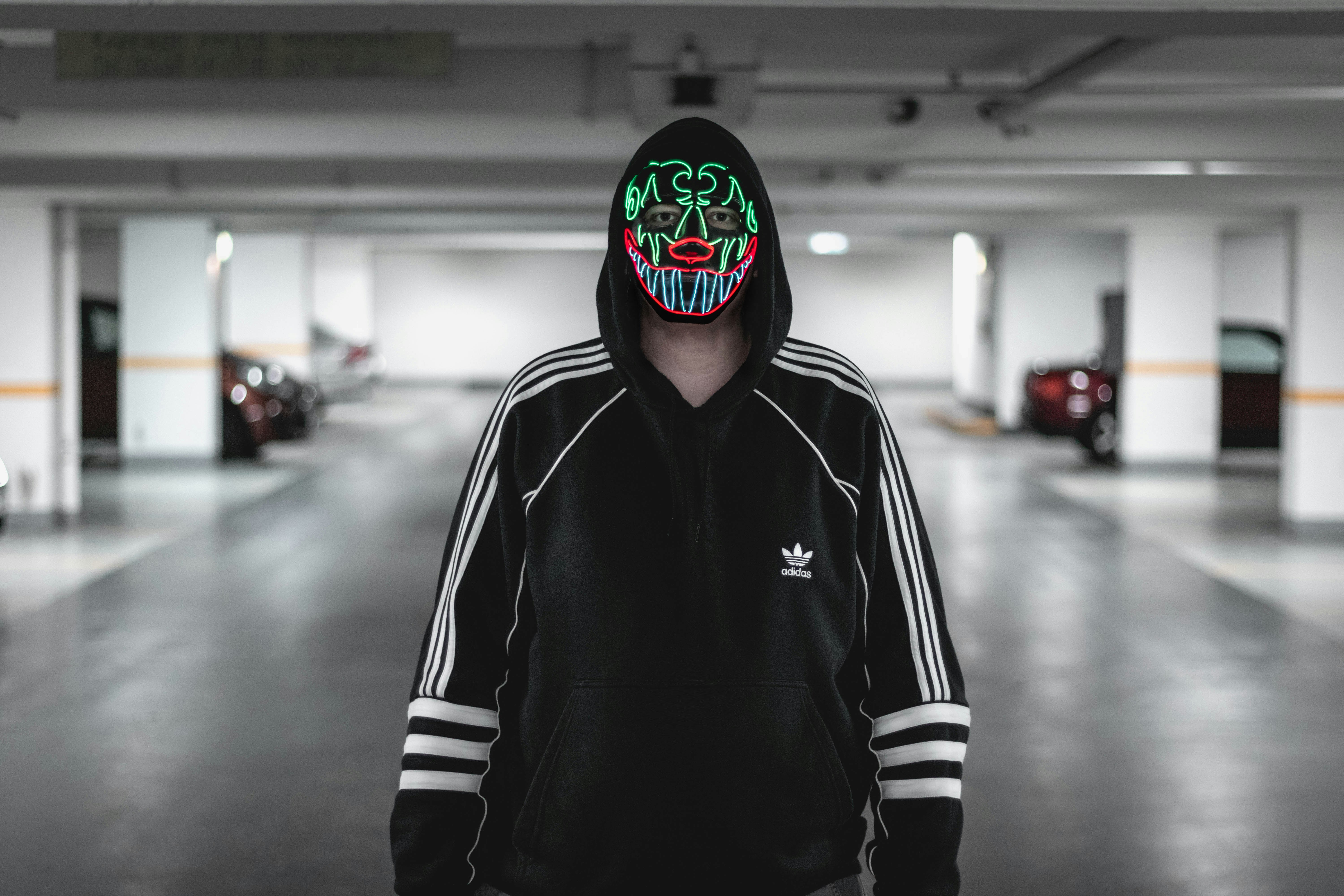 man wearing black and white adidas jacket wearing multicolored mask